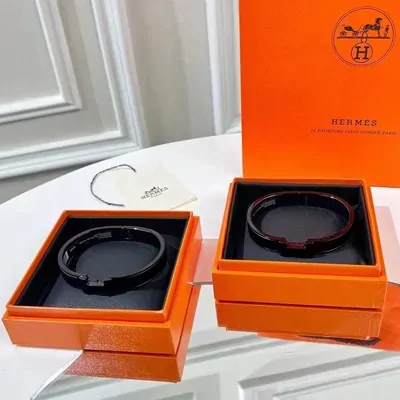 Dos pulseras de piel con cierre metálico dentro de cajas naranjas